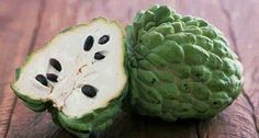 two pieces of green fruit sitting on top of a wooden table next to each other