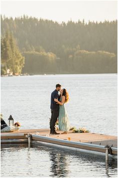 a bride and groom standing on a dock by the water