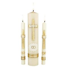 two candles with gold trimmings and crosses on them