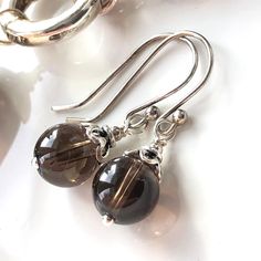 "7312 This beautiful pair of classic drop earrings were meticulously handcrafted with natural Smokey Quartz and Sterling Silver components. While offering elegant classic look, they are great for everyday wear or some special occasions. These earrings will make perfect birthday, anniversary, appreciation or holiday gift for yourself or special woman in your life - mom, wife, girlfriend, daughter, sister, grandma, niece, aunt, cousin, best friend, teacher, coach, doctor, caregiver or colleague.   This listing is for the EARRINGS only   NECKLACE shown for demo only and listed separately - search our shop for '7311' MATERIALS & DIMENSIONS ✦ Natural SMOKEY QUARTZ, brown grey, smooth round beads 8mm; ✦ STERLING SILVER bead caps, pins and fish hook ear wires; ✦ Total length of shown earrings is Classic Brown Jewelry With Matching Earrings, Classic Gemstone Earrings For Everyday, Classic Everyday Gemstone Earrings, Brown Gemstone Drop Earrings, Elegant Sterling Silver Earrings With Natural Stones, Elegant Brown Sterling Silver Earrings, Elegant Brown Drop Earrings, Elegant Smoky Quartz Jewelry For Formal Occasions, Elegant Brown Natural Stone Jewelry