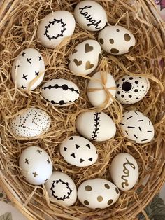 an easter basket filled with white eggs and decorated with handwritten words, on top of straw