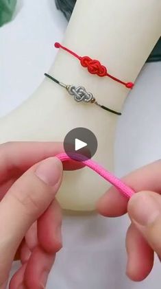 someone is tying a pink string to a bracelet