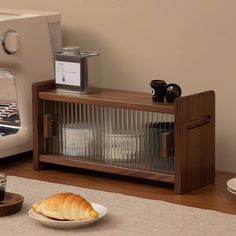 there is a plate with bread on it next to a toaster and coffee maker