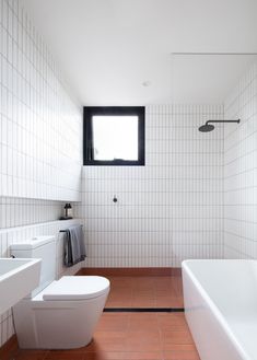 a bathroom with a toilet, sink and bathtub next to a window in the wall