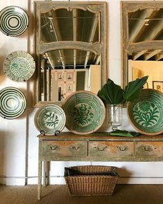 green and white plates are sitting on an old dresser