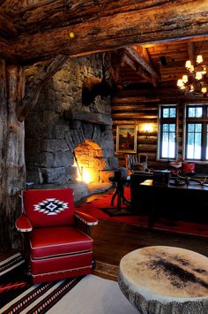 a living room with a fire place next to a couch and chair in front of a fireplace