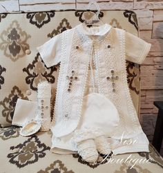 a baby's outfit and booties are sitting on a couch