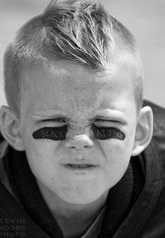 a young boy with his face painted black and white