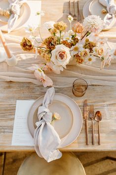 the table is set with flowers and silverware