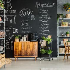 a chalkboard wall in the corner of a room filled with plants and other things