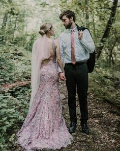 a man and woman standing in the woods