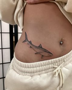 a woman's stomach with a shark tattoo on her lower belly and bottom part