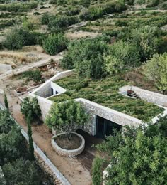 an aerial view of a building with plants growing on the roof and trees around it