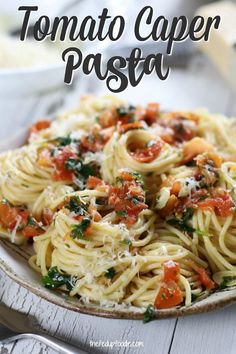 a plate of pasta with tomato sauce and parmesan cheese on top, sitting on a wooden table