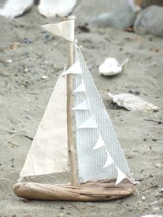 a toy sailboat is sitting on the sand