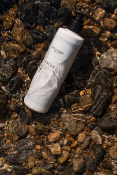 a tube of shampoo sitting on top of rocks