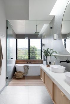 a bathroom with a tub, sink and large mirror on the wall next to it