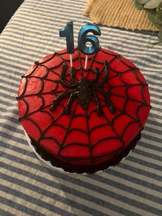 a spiderman birthday cake on a table with candles in the shape of number six