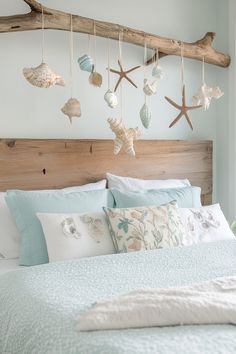 a bed with sea shells hanging from it's headboard and pillows on top