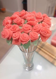 a glass vase filled with pink roses on top of a table