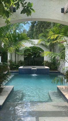 an outdoor swimming pool surrounded by greenery