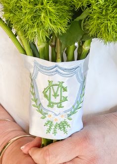 a person holding a bouquet of flowers with the initials m and d on it's side