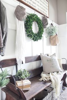 a wooden bench sitting next to a wall with wreaths on it and other decorations