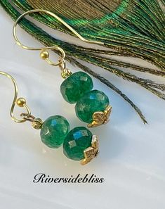 Grade AAA faceted Emerald Beaded Earrings! I accented these with tiny faceted gold brass ball beads and gold leaf shaped bead caps. They have 18k gold plated ear wires! Lovely green and a very nice sparkle! May Birthstone is Emerald please check measurements, as it can be difficult to determine the exact size from the photos!  MEASUREMENTS :  Earrings: 1 1/2" long including ear wires!  Faceted emerald beads: 8mm This is the exact pair of earrings that you will receive in the photos!! Bohemian Gold Earrings With Faceted Beads, Gold Beaded Earrings With Faceted Beads For Gifts, Gold Spiritual Beaded Earrings For Gifts, Gold Earrings With Faceted Round Beads, Faceted Round Beaded Earrings As Gift, Faceted Beaded Earrings With Round Beads As Gift, Faceted Round Bead Earrings As Gift, Brass Jewelry With Faceted Beads For Jewelry Making, Bohemian Gold Faceted Earrings