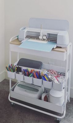 a sewing machine sitting on top of a white cart filled with craft supplies and scissors