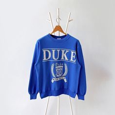 90s Duke University blue devils sweatshirt/ M * PLEASE READ BEFORE PURCHASE * PLEASE consider the PHOTOS before making the decision * The images may DIFFER in appearance from the actual product because we took pictures under daylight.  * PLEASE send your PHONE NUMBER after your purchase for the shipping company to contact you X No returns X No refund Condition : 9/10 More details : look at the pictures  Brand : Hanes Size : M Pit to pit/ Chests : 20.5/41 inches  Length : 26 inches  Material : cotton polyester  Color : blue * ALL ITEMS are VINTAGE which may show some signs of wear and tear * Due to the different display and different light, the picture may not reflect the actual color of the item * Please, remember that our items are vintage so they may show some signs of wear, tear and yel Blue Throwback Crew Sweatshirt, Blue Throwback Sweatshirt With Graphic Print, Blue Throwback College Sweatshirt, Vintage Blue Sweatshirt For College, Retro Blue College Sweatshirt, Retro Blue Sweatshirt For College, Blue Retro Sweatshirt For College, Duke Sweatshirt, University Sweater