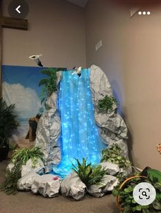 an indoor waterfall with plants and rocks