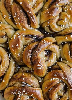 a white plate topped with lots of pretzels covered in sesame seeds and sea salt