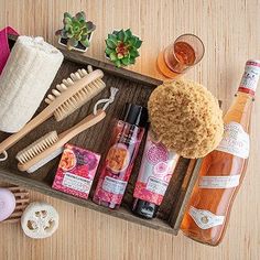 the contents of a wooden tray are arranged on top of a wood table, including hair products and soaps