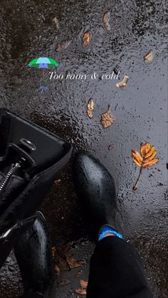 a person standing in the rain with their feet up and an umbrella over their head