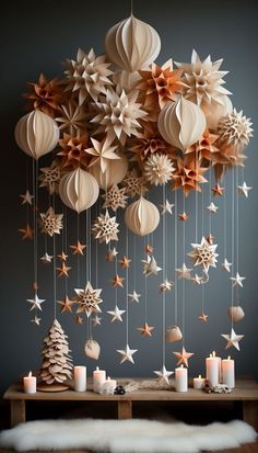 a table topped with lots of paper stars hanging from it's sides and candles