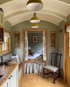 a bedroom with a bed, desk and chair in it's center area next to two windows