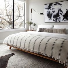 a bedroom with a bed, rug and window