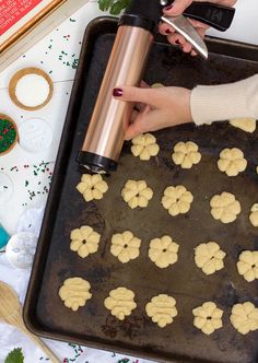 a person is making cookies on a baking sheet