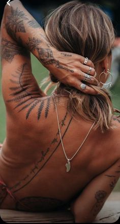 a woman with tattoos sitting on the ground