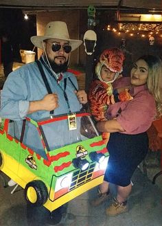 two women and a man in costume standing next to a car