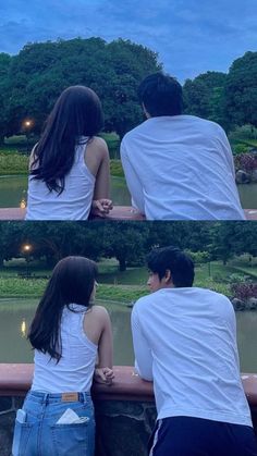 two people sitting next to each other on a bridge looking at the water and trees