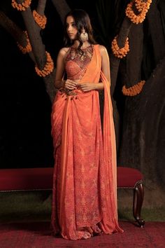 Orange to maroon ombre pre-draped concept saree with all over floral prints and hand embroidered brooch on the waist. Paired with a padded blouse with floral embroidery, mesh detailing and geometric cut-outs. - Aza Fashions Concept Saree, Orange Flats, Orange Saree, Embroidered Brooch, Padded Blouse, Drape Saree, Blouse For Women, Saree With Blouse, Printed Sarees