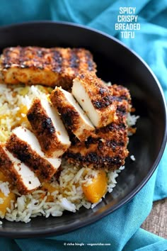 chicken and rice in a black bowl on a blue towel with the words spicy crispy breaded tofu