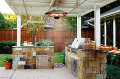 an outdoor kitchen with grill and sink in the back yard