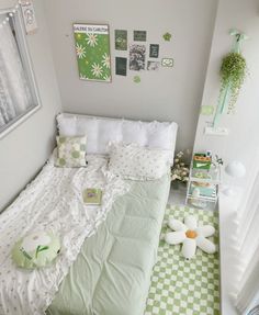 a bedroom with green and white checkered flooring, pictures on the wall above the bed