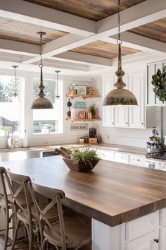 a kitchen with an island and hanging lights