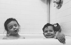 two children are playing in the bathtub