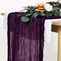 a purple table runner with flowers and greenery