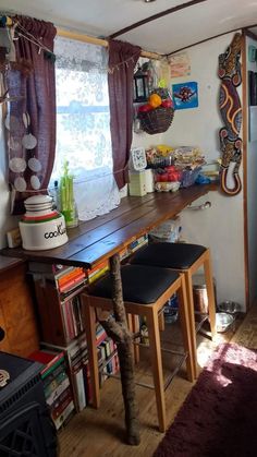 there is a table with two stools in front of it and bookshelves on the wall