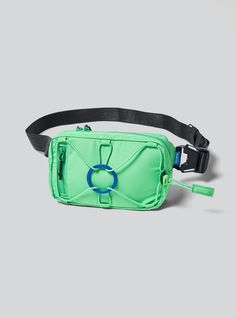 a green fanny bag with a blue circle on the front and black strap around it